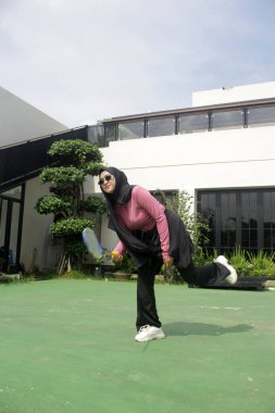 Parkta badminton oynayan Asyalı kadın.