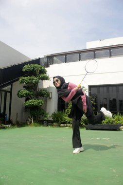 Parkta badminton oynayan Asyalı kadın.