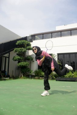 Parkta badminton oynayan Asyalı kadın.