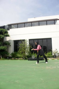 Parkta badminton oynayan Asyalı kadın.