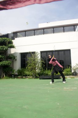 Parkta badminton yapan genç bir kadın