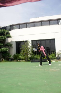 Parkta badminton yapan Asyalı kadın.