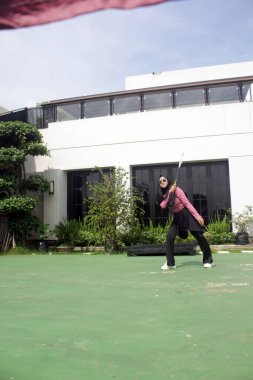 Parkta badminton yapan Asyalı kadın.