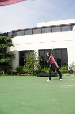 Parkta badminton yapan Asyalı kadın.