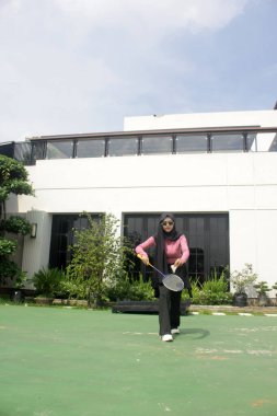 Parkta badminton yapan Asyalı kadın.