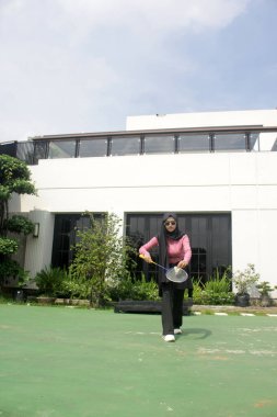 Parkta badminton yapan Asyalı kadın.