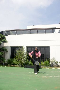 Parkta badminton yapan Asyalı kadın.