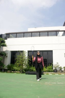 Parkta badminton yapan Asyalı kadın.