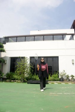 Parkta badminton yapan Asyalı kadın.