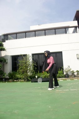 Parkta badminton yapan Asyalı kadın.
