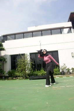 Parkta badminton yapan Asyalı kadın.