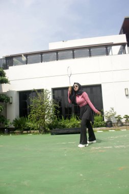 Parkta badminton yapan Asyalı kadın.