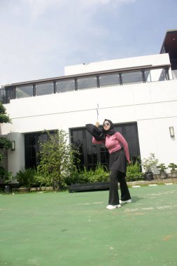 Parkta badminton yapan Asyalı kadın.