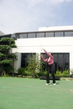 Parkta badminton yapan Asyalı kadın.