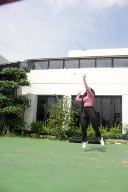 Parkta badminton yapan Asyalı kadın.