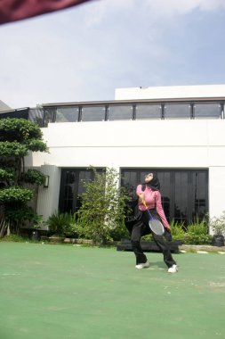 Parkta badminton yapan Asyalı kadın.