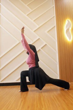 Genç bir kadın spor salonunda esneme egzersizi yapıyor. Sağlıklı bir kadın esneme egzersizleri yapıyor. Zindelik, sağlıklı yaşam tarzı, sağlık..