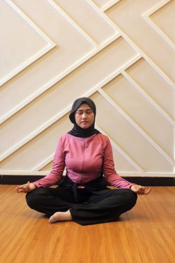 Genç Müslüman kadın yoga yapıyor.