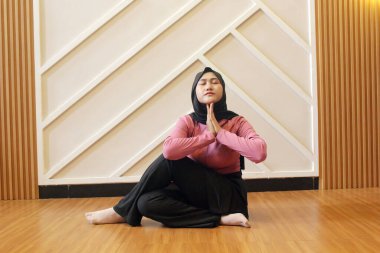 Kadın yoga yapıyor, oturuyor ve lotus pozisyonunda meditasyon yapıyor.