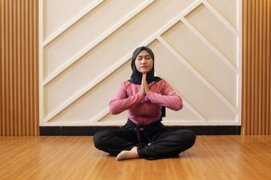 Spor salonunda yoga yapan Asyalı Müslüman kadın..