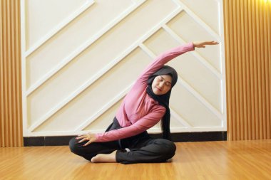 Güzel, genç Asyalı kadın yoga stüdyosunda vücudunu esnetiyor..