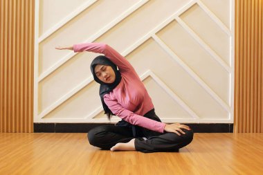 Güzel Müslüman kadın stüdyoda yoga yapıyor.