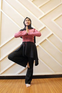 Genç Asyalı kız evde yoga yapıyor.