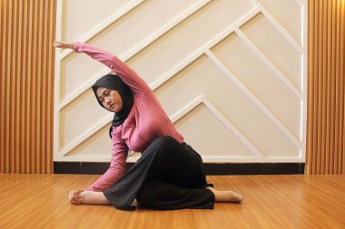 Asyalı kadın spor salonunda yoga yapıyor.