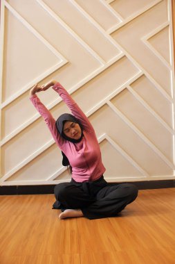 Yoga pozu veren güzel genç bir kadın.