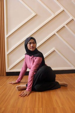 Yoga pozu veren Müslüman kadın.