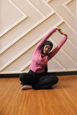 Genç Müslüman kadın evde yoga yapıyor..