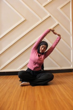 Spor salonunda yoga yapan genç bir kadın.