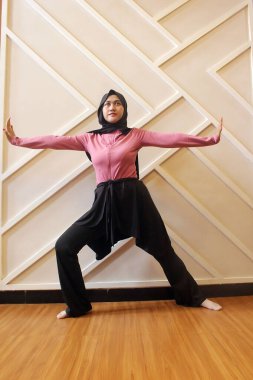 Müslüman kadın dansçı bir stüdyoda gösteri yapıyor.