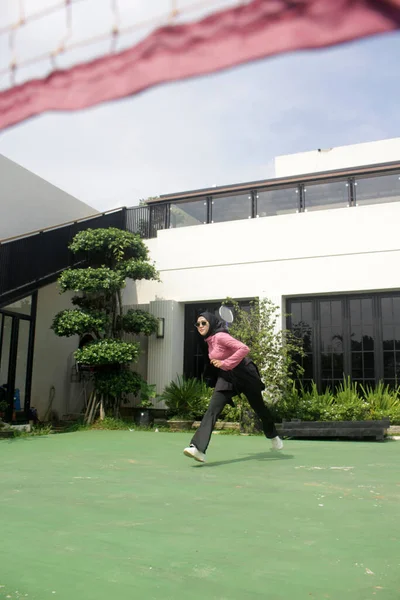 Parkta badminton oynayan Asyalı kadın.