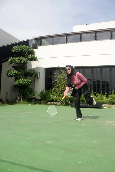 Parkta badminton oynayan Asyalı kadın.