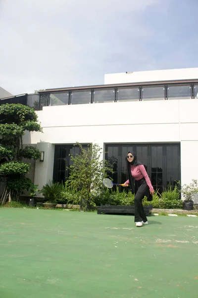 Parkta badminton oynayan Asyalı kadın.