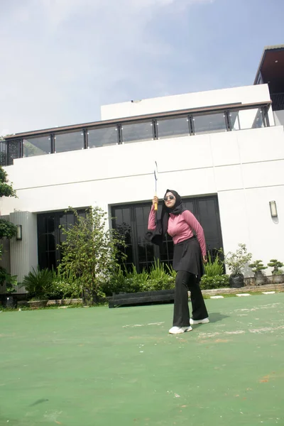 Parkta badminton yapan Asyalı kadın.