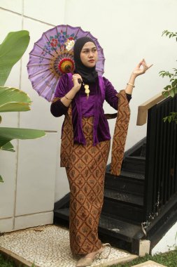 Bahçede geleneksel kıyafetler giyen Asyalı bir kadın.