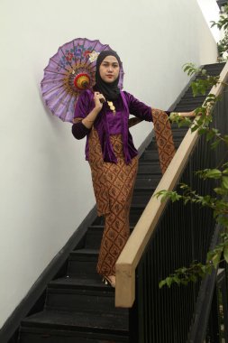 Tayland tarzı geleneksel bir elbise giyen genç Asyalı kız başörtüsüyle