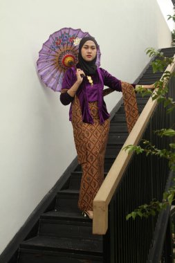 Çatıda atkısı olan genç bir kadın.