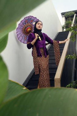 Evde poz veren tesettürlü genç Müslüman kadın.