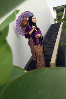 Endonezya 'da geleneksel şapkalı, geleneksel giysili güzel Müslüman kadın..