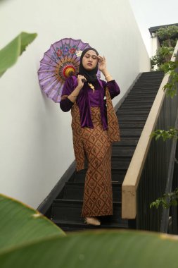 Geleneksel bir Malay elbisesi giyen Asyalı Müslüman bir kadının portresi..