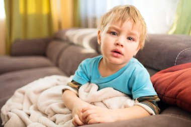 üzgün çocuk odasında bir battaniyenin altında oturur