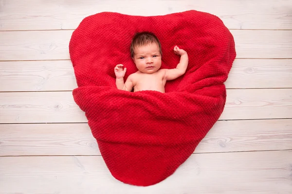 Bebé recién nacido durmiendo en una manta roja en forma de corazón —  Fotos de Stock