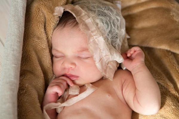 A criança recém-nascida em um gorro dorme em uma manta — Fotografia de Stock