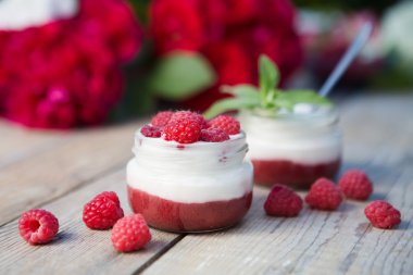 Yoğurtlu taze ahududu ahşap arka plan üzerinde. sağlıklı sabah kahvaltı.