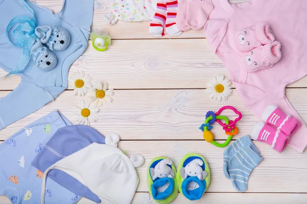 De kleren van de pasgeboren baby op houten achtergrond — Stockfoto