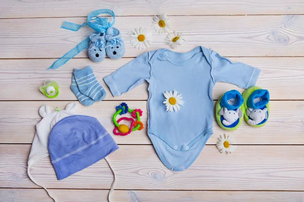 ahşap arka plan üzerinde yeni doğan bebek giysileri