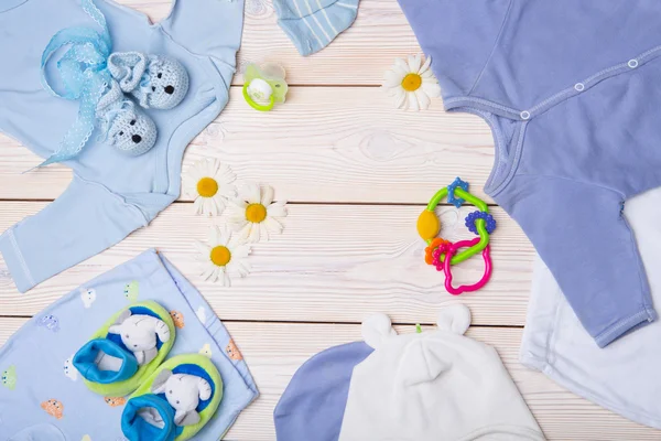 Roupas de bebê recém-nascido em fundo de madeira — Fotografia de Stock